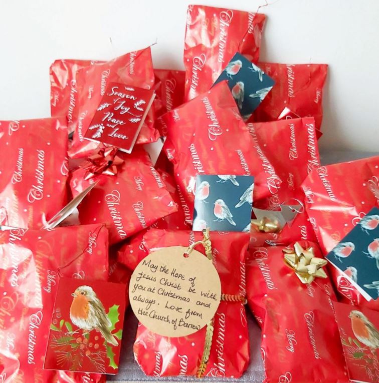 Collection of wrapped knitted crosses with gift tags