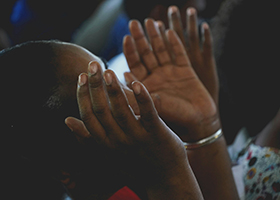 A person with hands raised in prayer