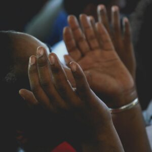 A person with hands raised in prayer